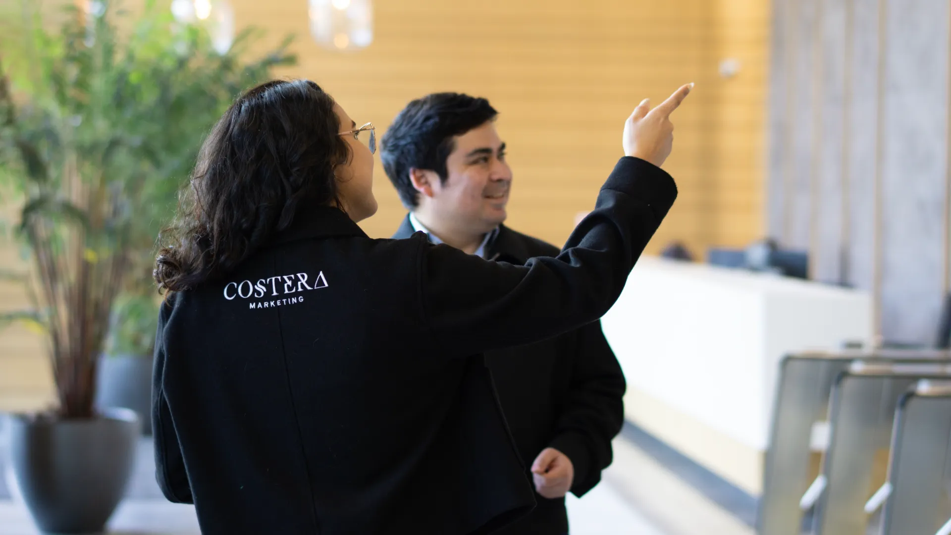 Dos empleados de Costera Group trabajando desde un computador portatil